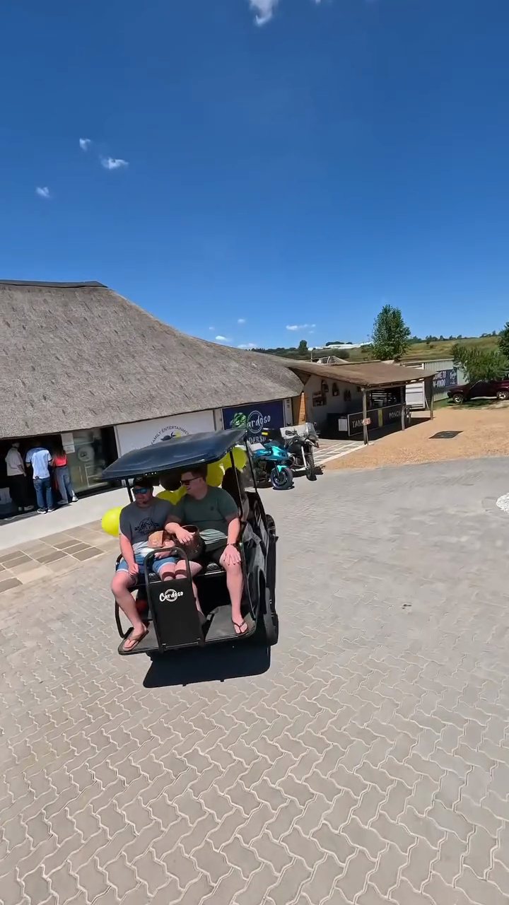 Golf carts by the thatched buildings